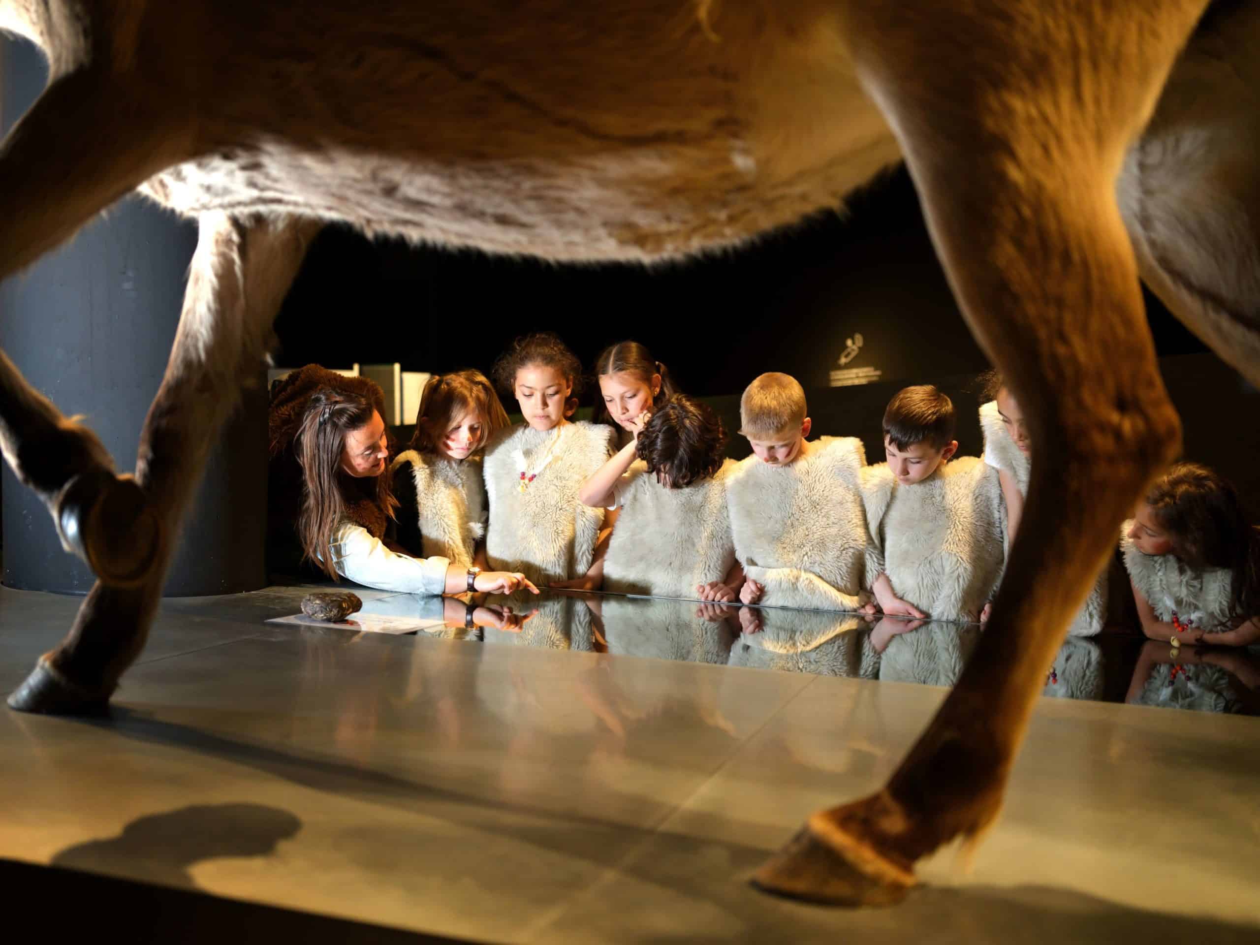 Kinderen en gids tijdens 'De oermens' in het Gallo-Romeins Museum